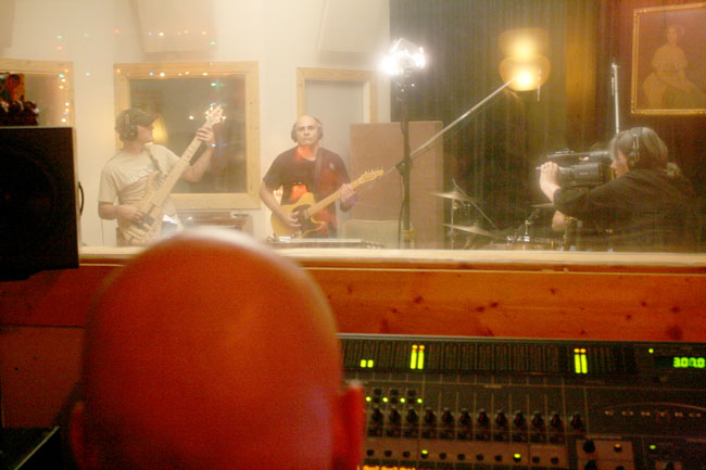 A scene from inside the control room: music Producer Winn McElroy looks on as "Oxford Sounds" Producer Marie Antoon films bassist Tommy Turan and Guitarist Max Williams of the band George McConnell & The Nonchalants. Photograph by Newt Rayburn.